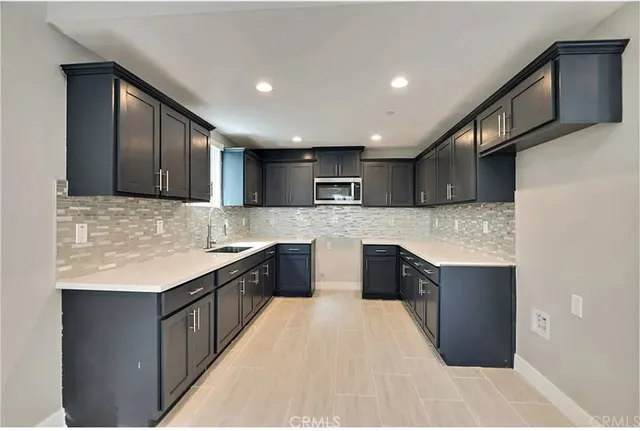 a kitchen with a sink a window and cabinets