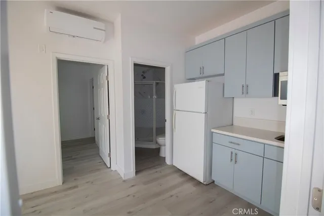 an empty room with wooden floor and mirror