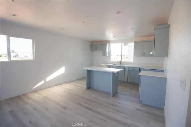 a kitchen with a sink cabinets wooden floor and a window