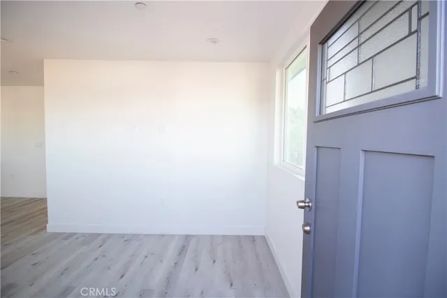 a view of a room with wooden floor and small window