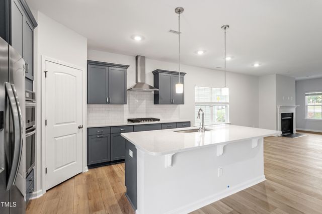 a large kitchen with stainless steel appliances granite countertop a sink a stove and a refrigerator