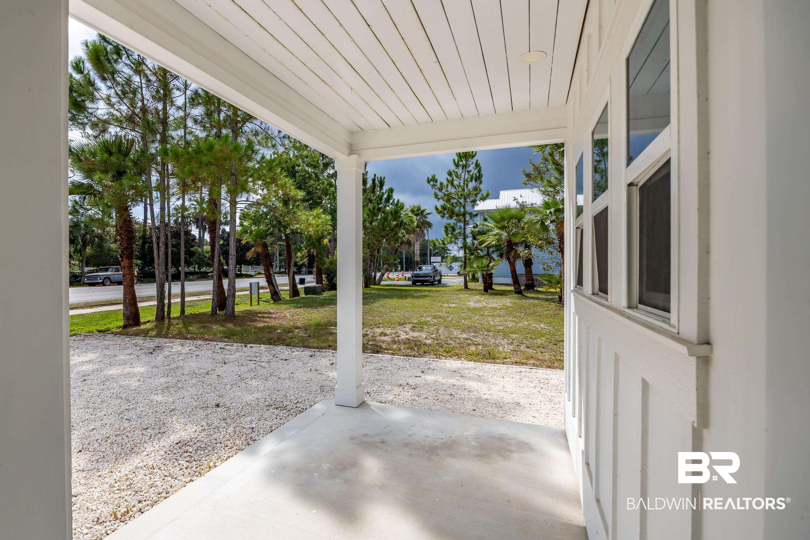 27591 Canal Road Orange Beach, AL 36561 - Photo 6 of 51 Covered porch featuring a lawn