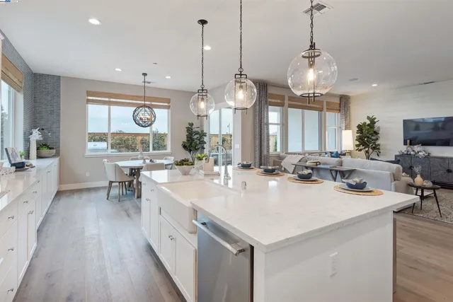 a kitchen with a sink a stove and white cabinets