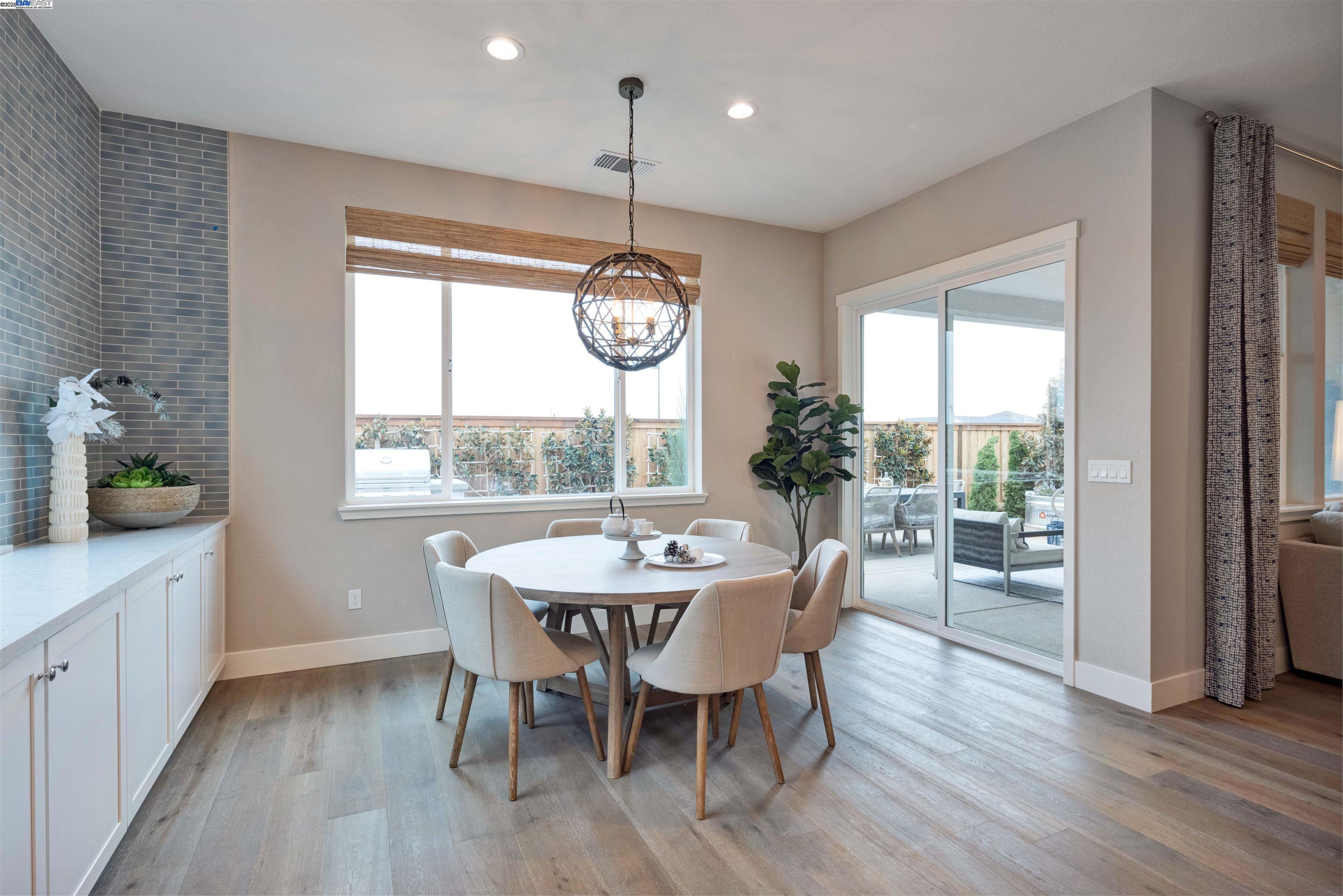 1371 Crescent Avenue Manteca, CA 95336 - Photo 22 of 55 a dining room with wooden floor a chandelier a wooden table and chairs
