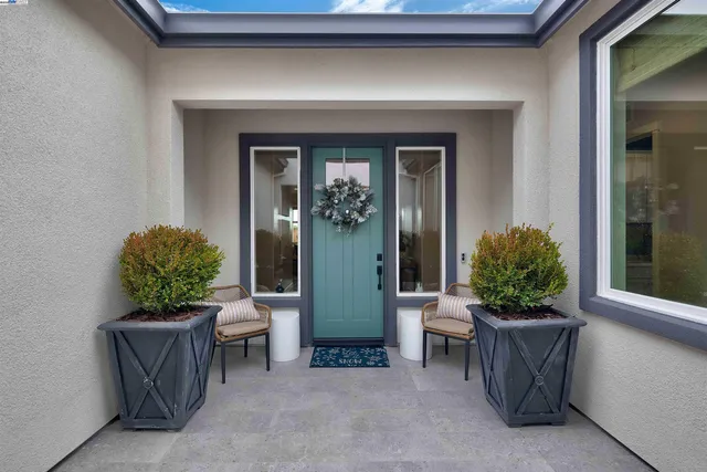 a view of a entryway door and potted plants
