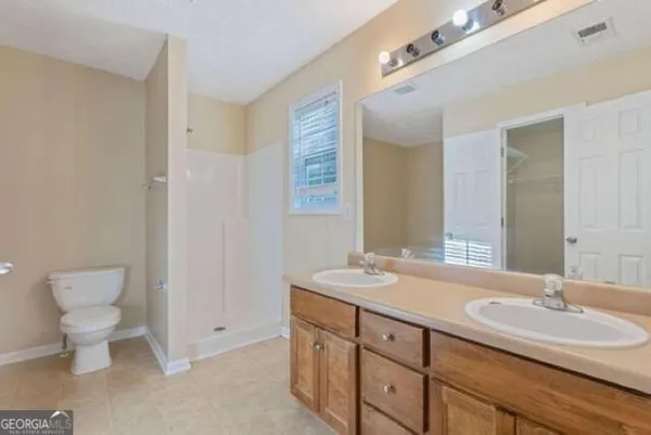 a bathroom with a double vanity sink and a toilet