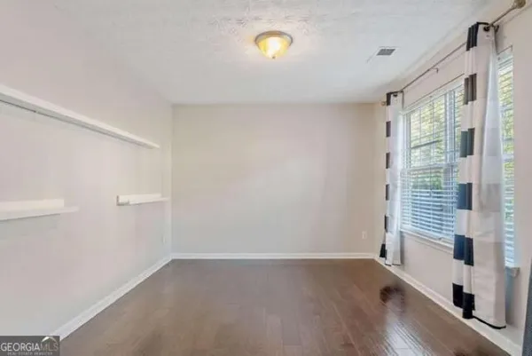 a view of a room with a window and wooden floor