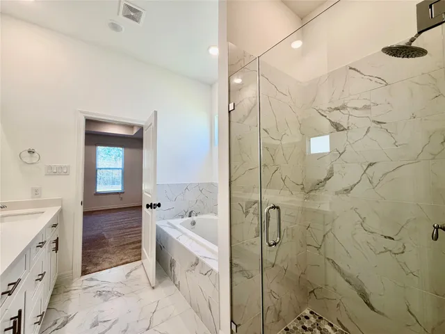 a spacious bathroom with a double vanity sink a mirror and a bathtub