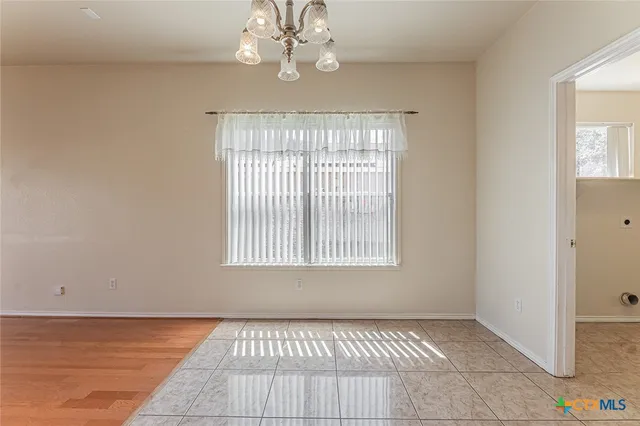 an empty room with windows and ceiling fan