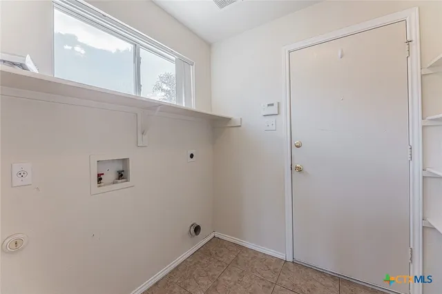 an empty room with windows and ceiling fan