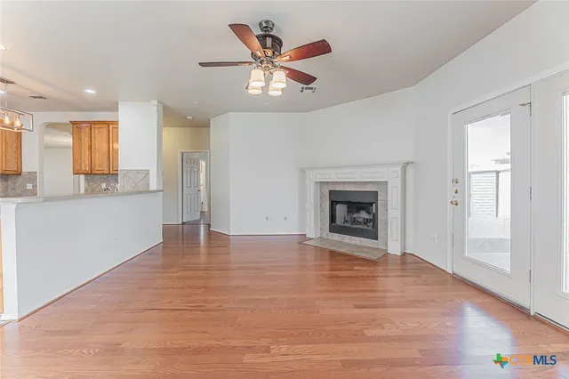 a view of an empty room with a window and a kitchen