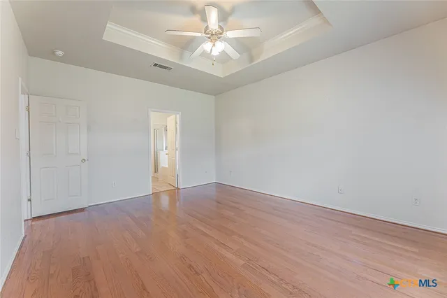 an empty room with a ceiling fan and a window