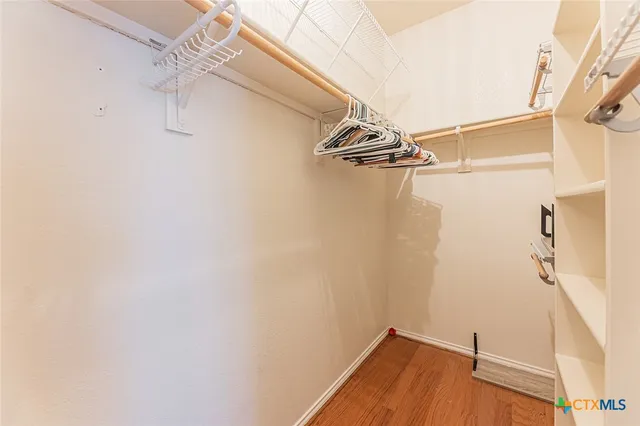 an empty room with closet and a ceiling fan
