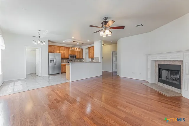 a view of a kitchen with a sink a refrigerator and a fireplace