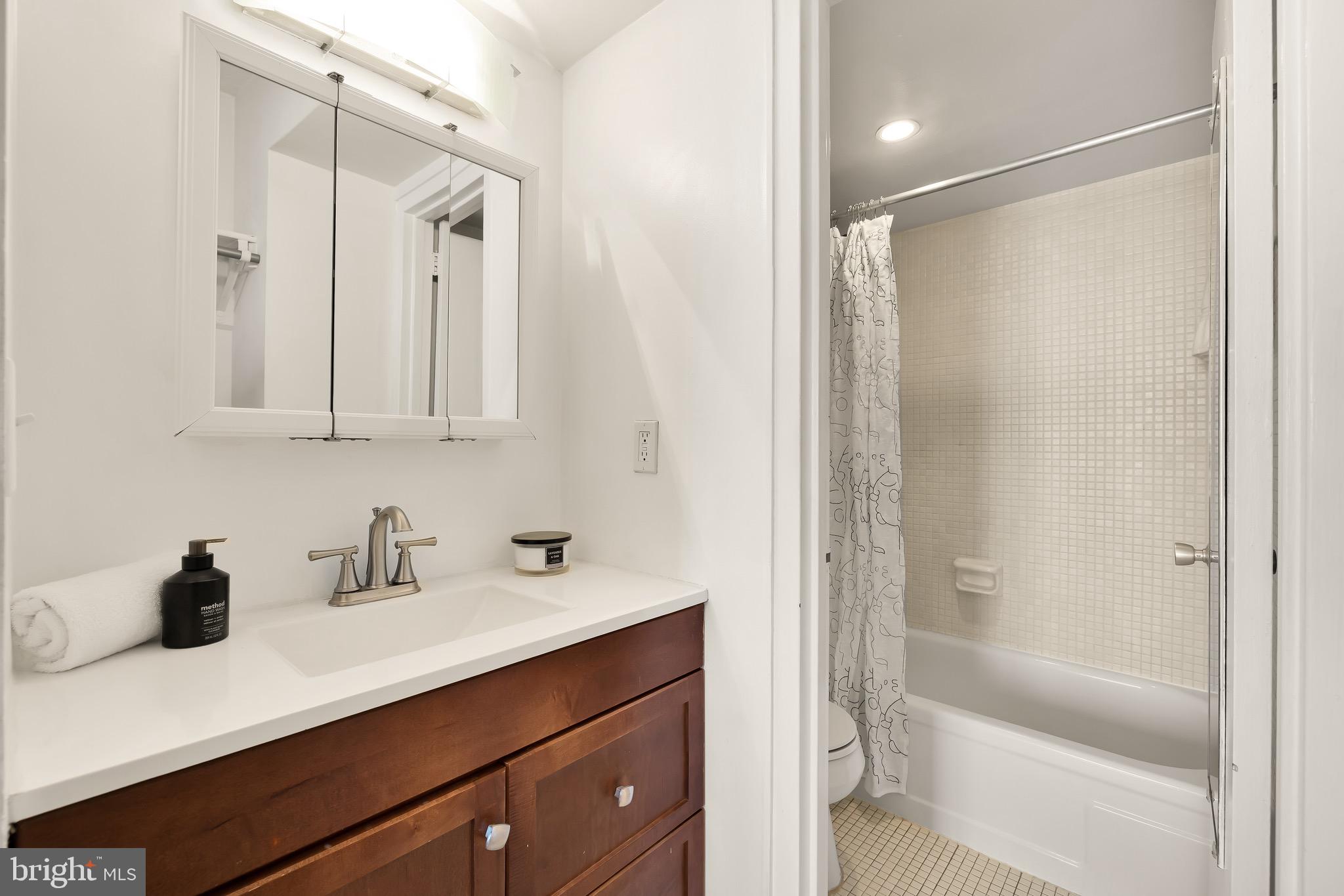 1800 R Street Northwest, Unit 807 Washington, DC 20009 - Photo 23 of 23 a bathroom with a shower sink vanity and mirror