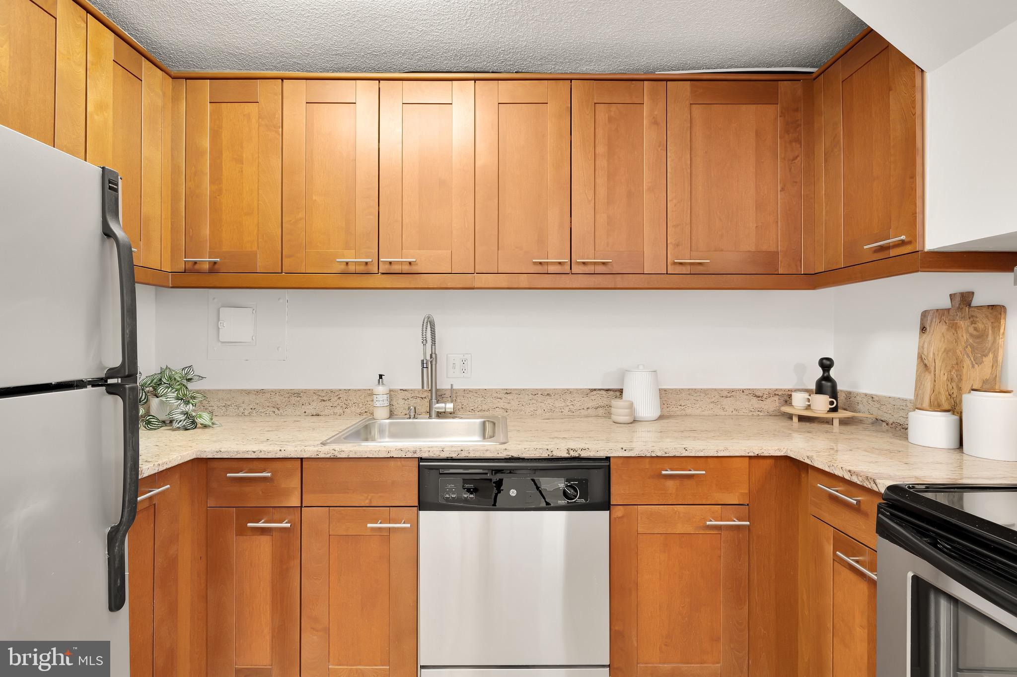 1800 R Street Northwest, Unit 807 Washington, DC 20009 - Photo 10 of 23 a kitchen with stainless steel appliances granite countertop a sink a stove a refrigerator with grey cabinets and wooden floor