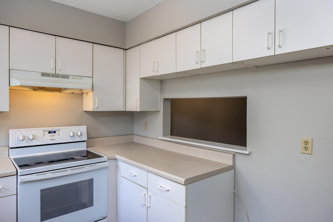 4265 Lake Ridge Drive, Unit 7C Raleigh, NC 27604 - Photo 5 of 19 a kitchen with white cabinets and white appliances