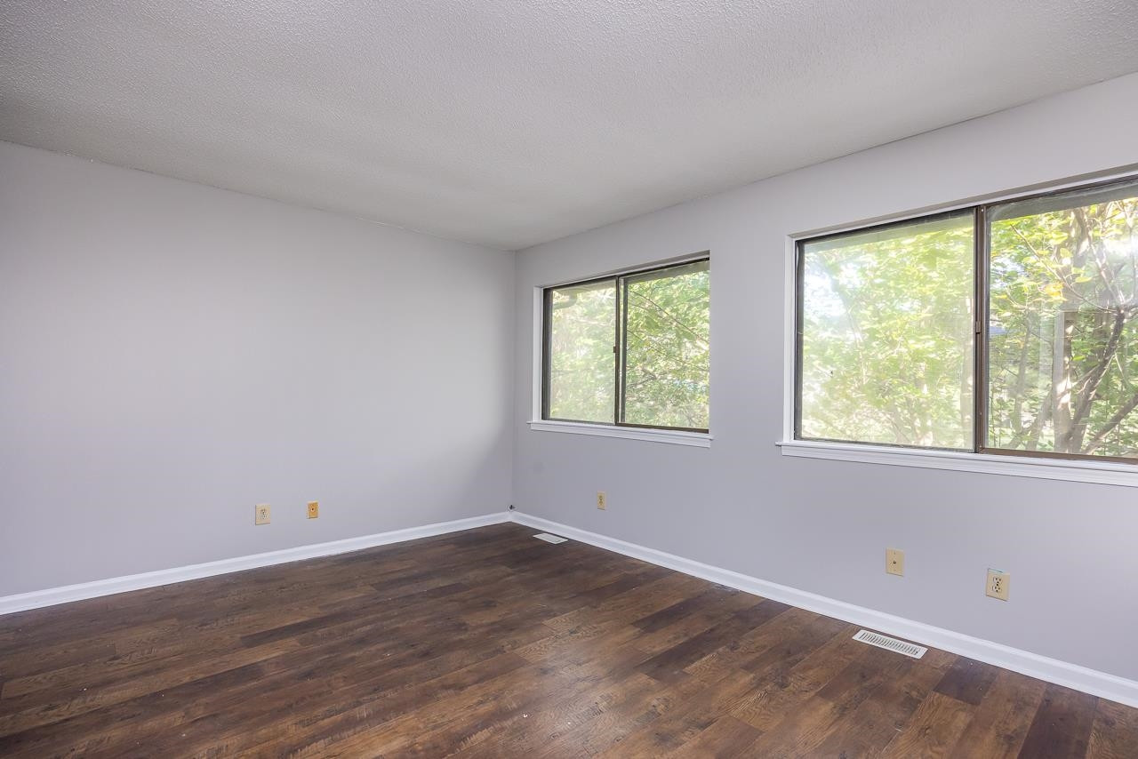 4265 Lake Ridge Drive, Unit 7C Raleigh, NC 27604 - Photo 7 of 19 an empty room with wooden floor and windows