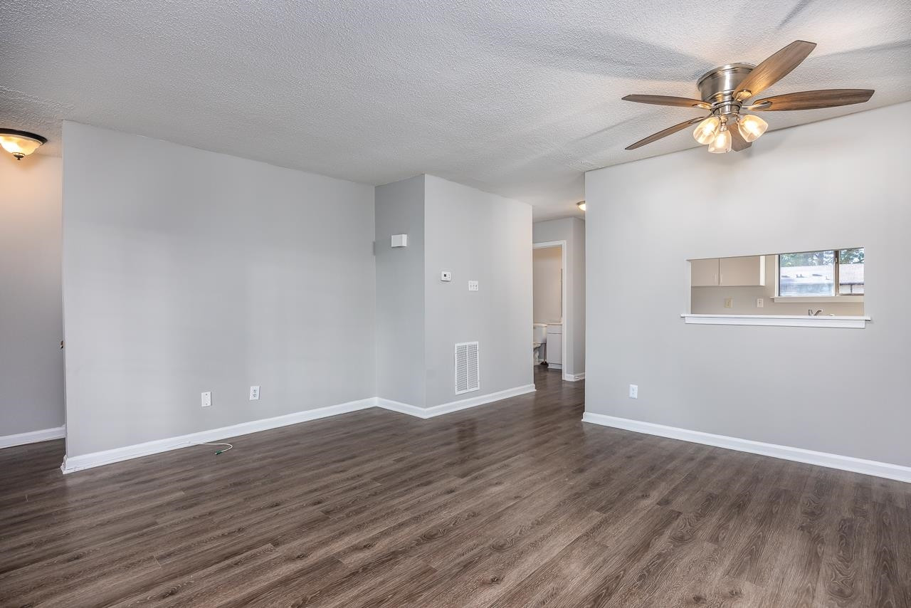 4265 Lake Ridge Drive, Unit 7C Raleigh, NC 27604 - Photo 9 of 19 a view of an empty room with wooden floor and a window