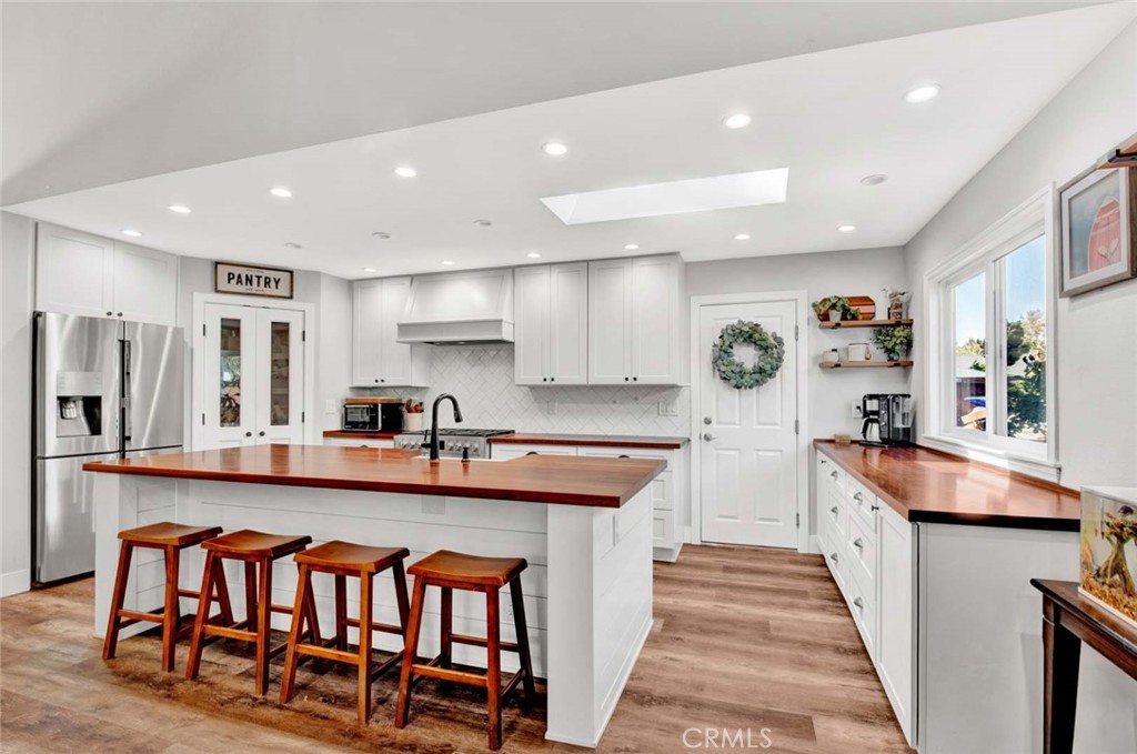 a large kitchen with stainless steel appliances granite countertop a stove and a dining table