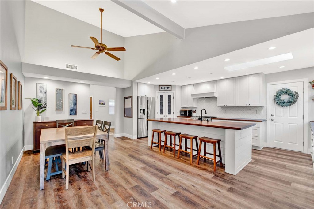 14762 Bridgeport Road Tustin, CA 92780 - Photo 8 of 29 a large kitchen with stainless steel appliances a table chairs refrigerator and wooden floor