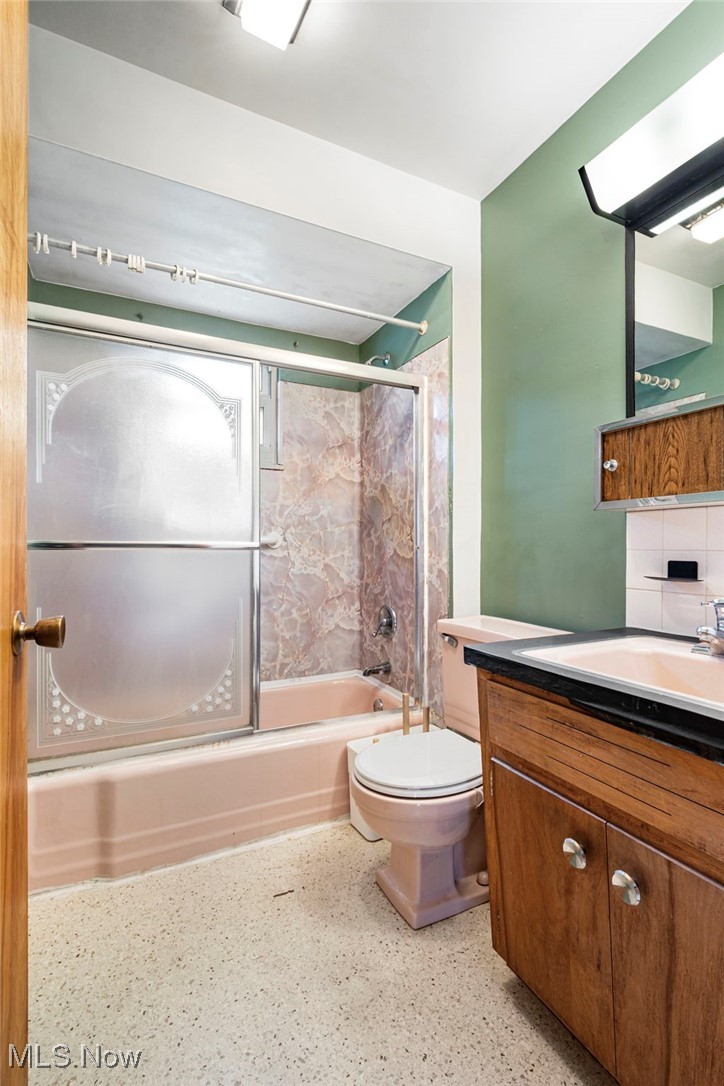3966 Wadsworth Road Barberton, OH 44203 - Photo 17 of 28 Bathroom with vanity, bath / shower combo with glass door, and backsplash