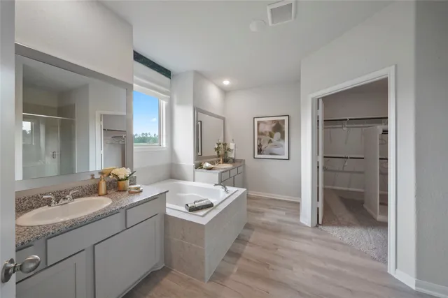 a spacious bathroom with a double vanity sink a mirror and a shower