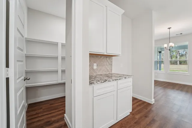 a kitchen with white cabinets and a stove