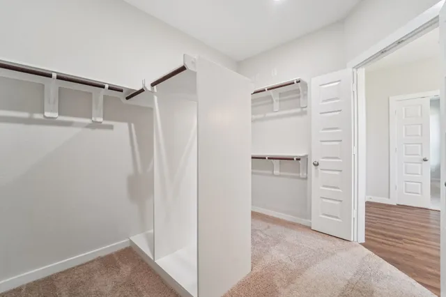 a view of walk in closet with empty racks