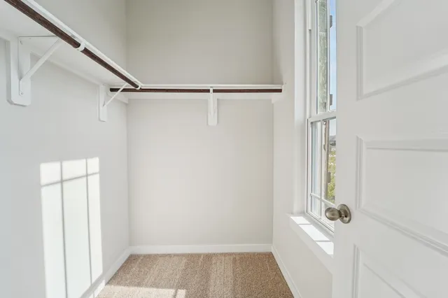 a view of walk in closet with empty racks