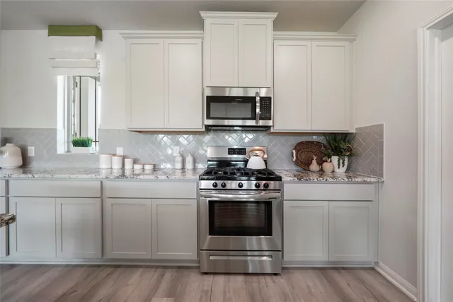 a kitchen with stainless steel appliances granite countertop a sink and a stove