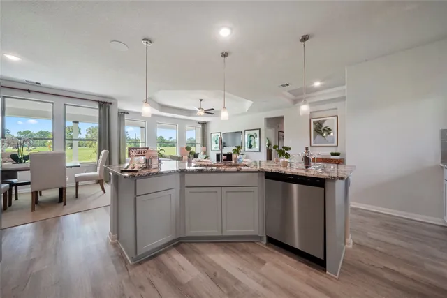 a kitchen with stainless steel appliances granite countertop wooden floors sink and cabinets