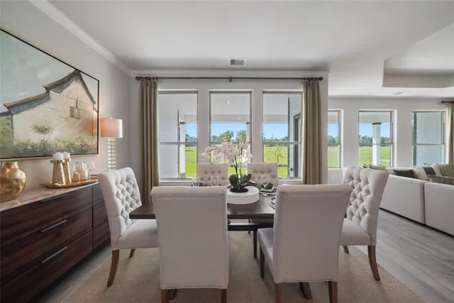 a view of a dining room with furniture large windows and wooden floor