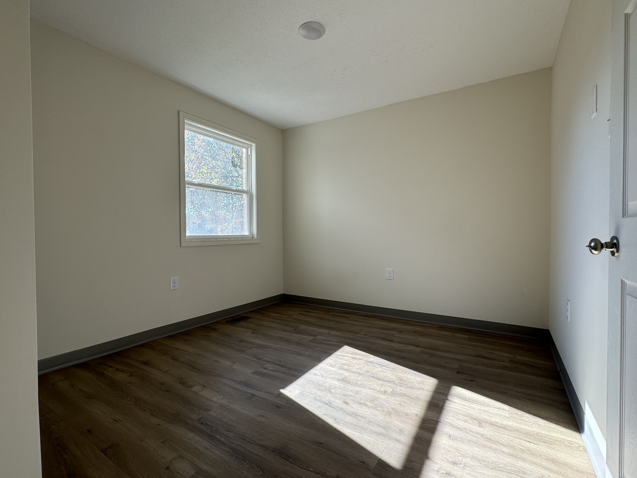 204 South Clydeton Road, Unit A Waverly, TN 37185 - Photo 11 of 14 an empty room with wooden floor and windows