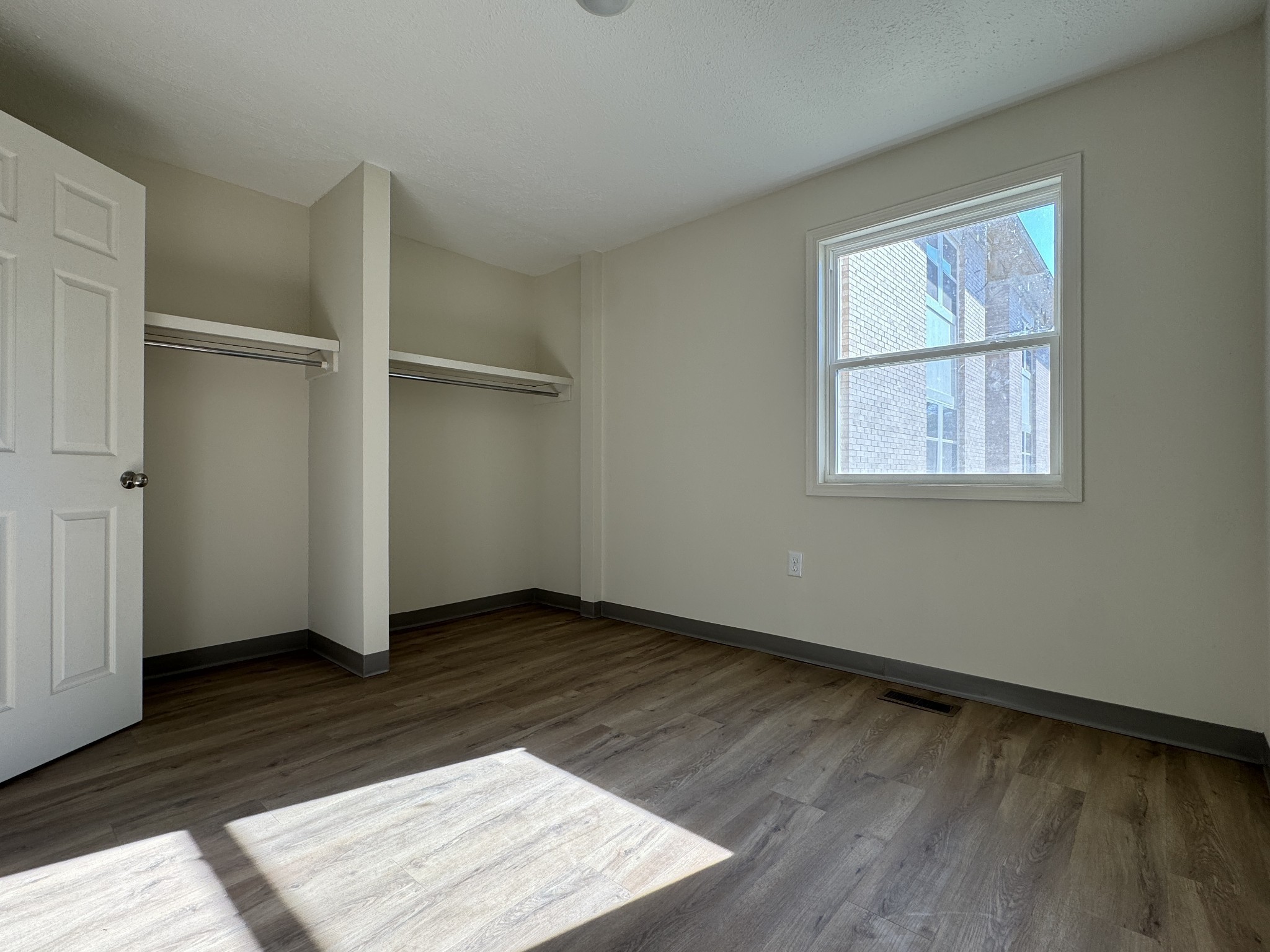 204 South Clydeton Road, Unit A Waverly, TN 37185 - Photo 12 of 14 an empty room with wooden floor cabinet and windows