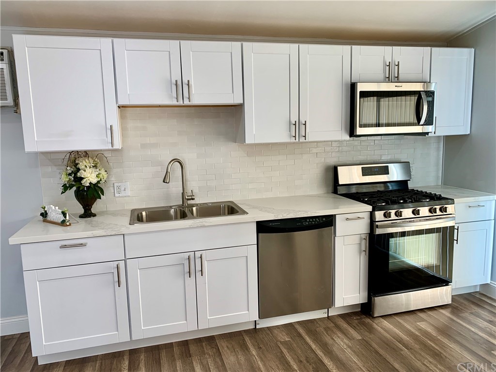 a kitchen with white cabinets stainless steel appliances and sink