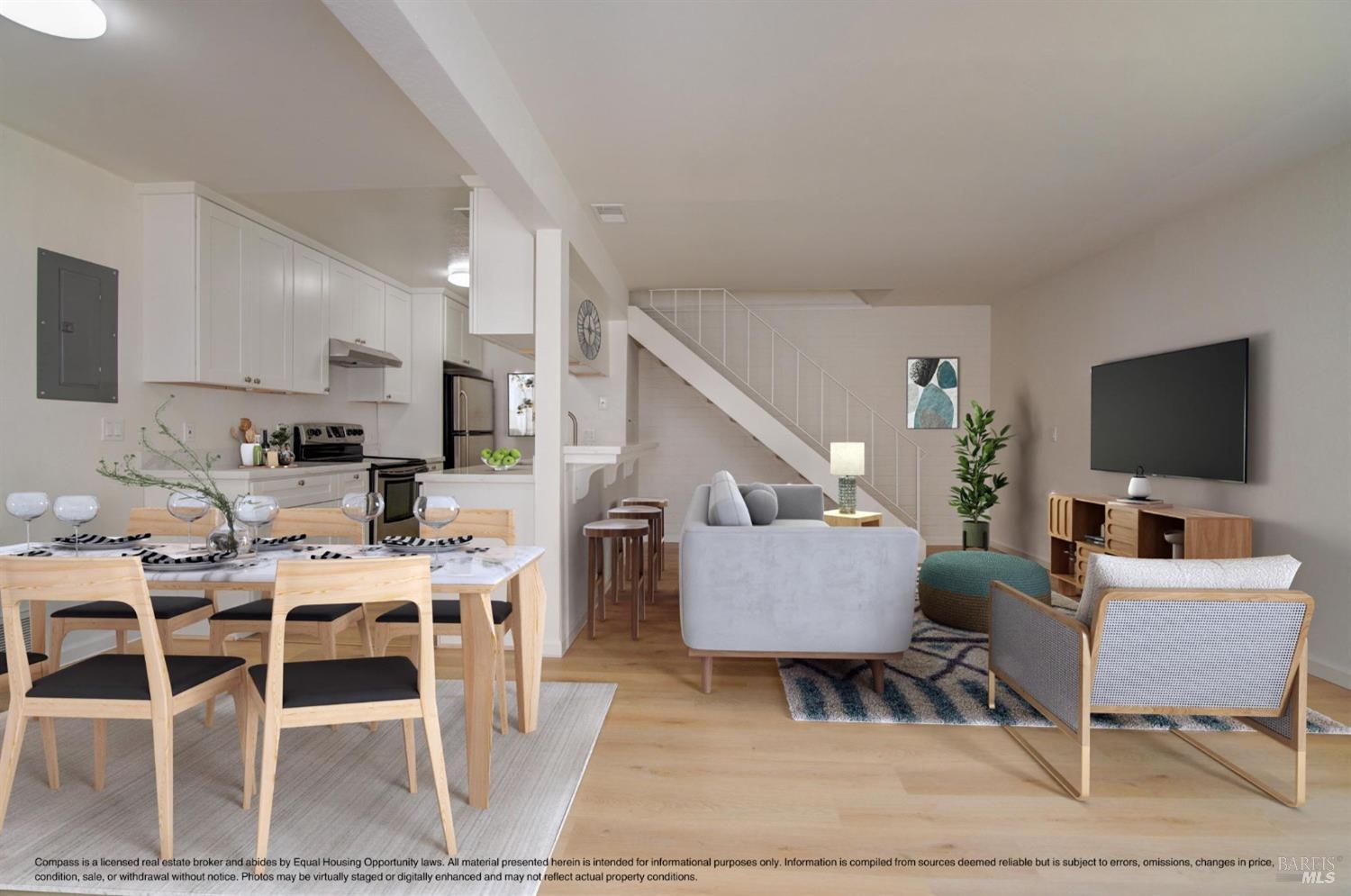 a living room with furniture a flat screen tv and kitchen view