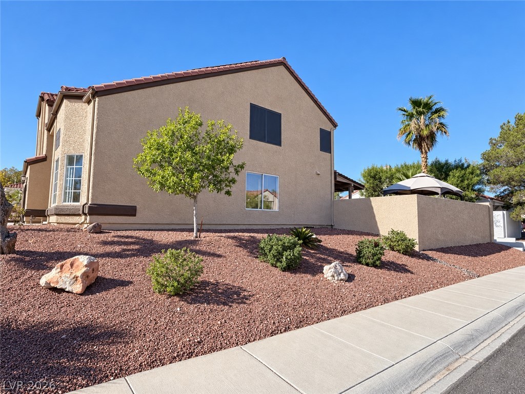 43 Bayridge Road Henderson, NV 89074 - Photo 6 of 47 Low-maintenance desert landscaping borders this two-story stucco home topped with a tile roof.