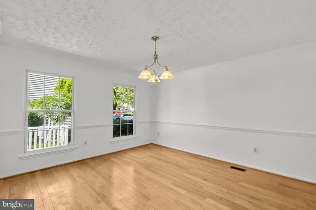 a view of an empty room with window and cabinet