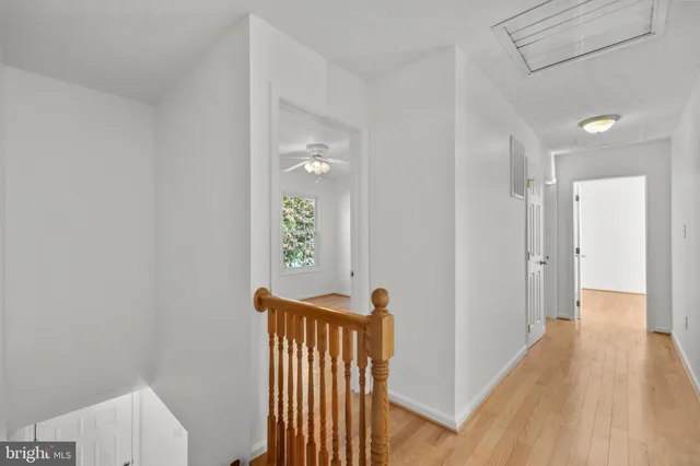 a view of an empty room and chandelier fan