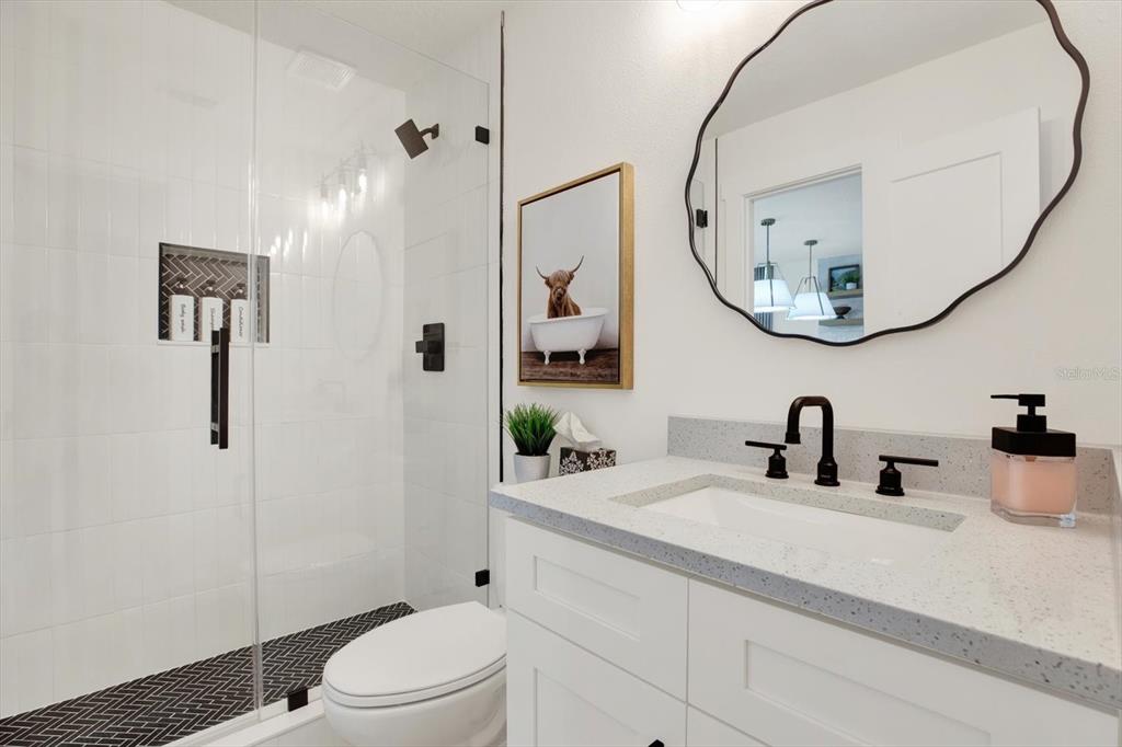 Undisclosed Address Tampa, FL 33607 - Photo 14 of 31 a bathroom with a sink a toilet and a mirror