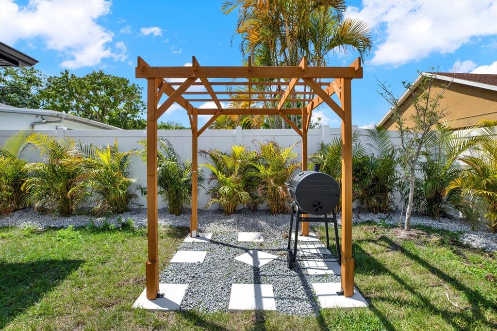 Undisclosed Address Tampa, FL 33607 - Photo 29 of 31 a backyard of a house with barbeque oven table and chairs
