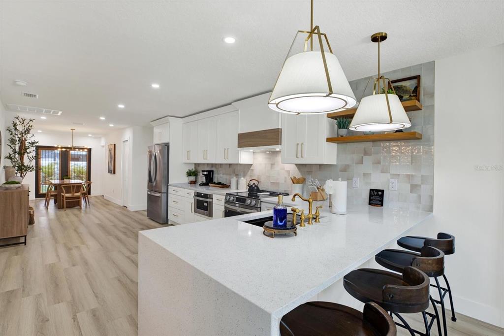 Undisclosed Address Tampa, FL 33607 - Photo 6 of 31 a kitchen with stainless steel appliances a dining table chairs stove and white cabinets