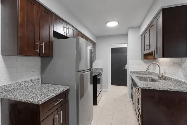 a kitchen with stainless steel appliances granite countertop a sink stove and refrigerator