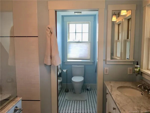 a bathroom with a granite countertop sink toilet and shower