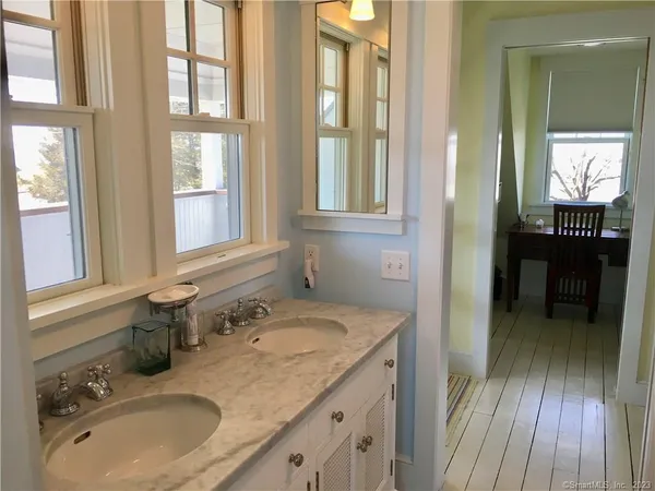a bathroom with a granite countertop sink mirror and a window