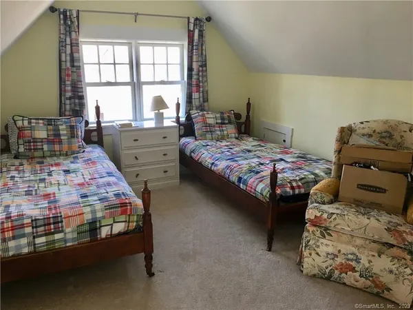 a bedroom with two beds and large windows