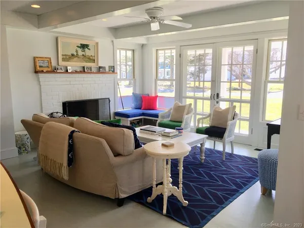 a living room with furniture a fireplace and a large window