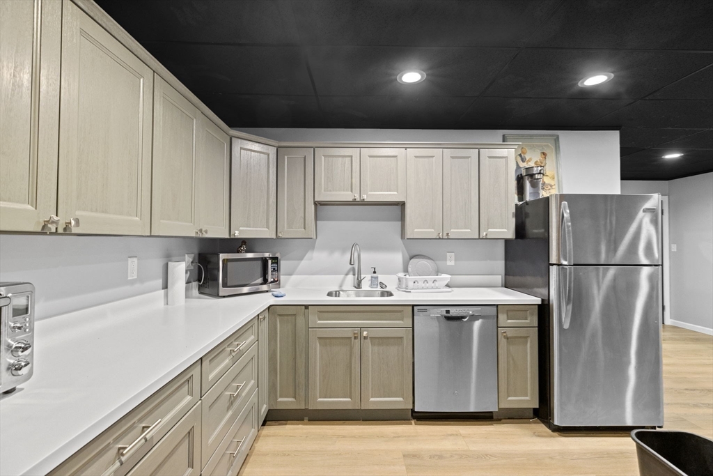 96 Deborah Road Hanover, MA 02339 - Photo 39 of 41 a kitchen with a sink a refrigerator and cabinets