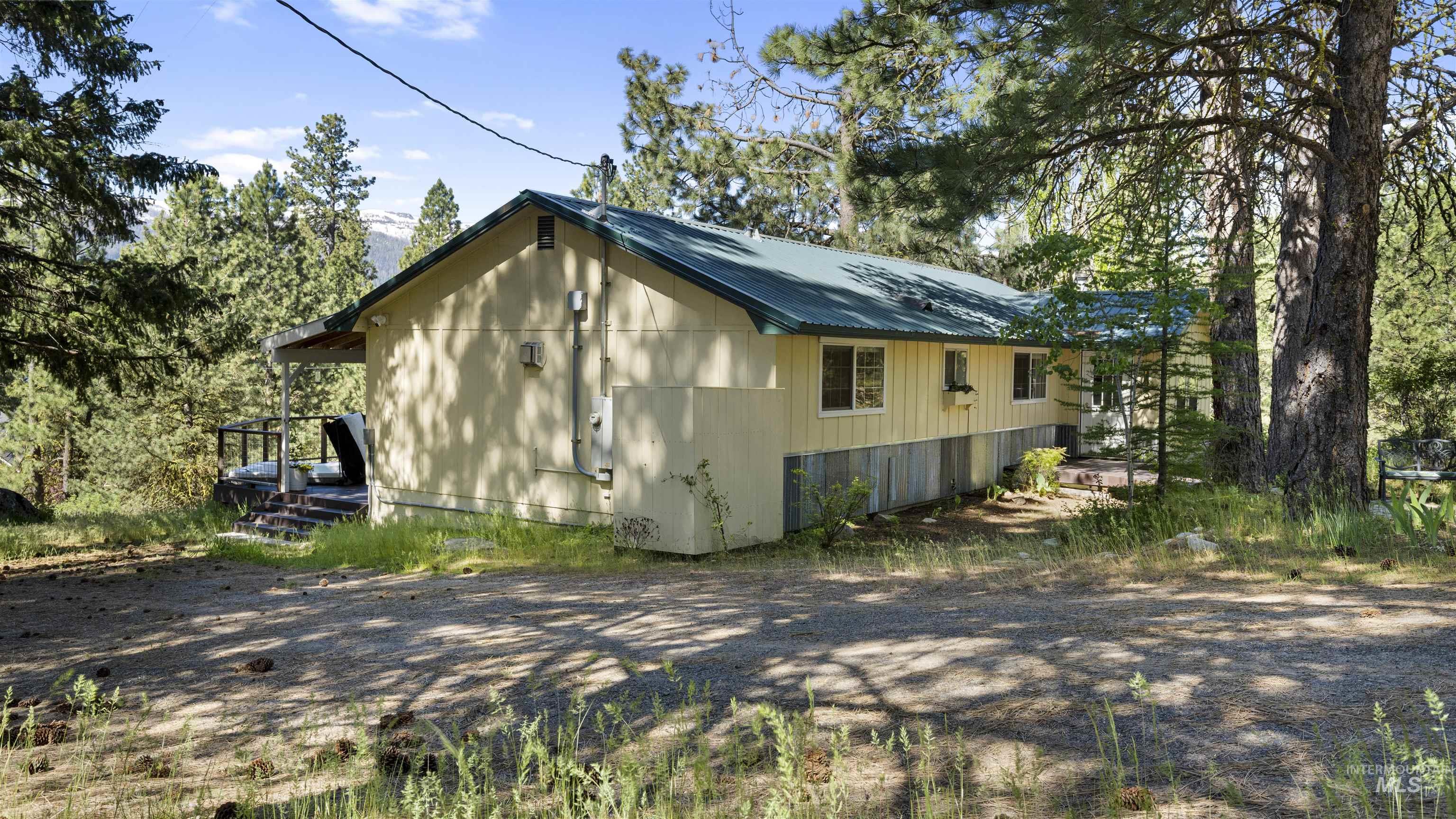 3 Laguna Place Cascade, ID 83611 - Photo 39 of 43 Single-story residence featuring light yellow siding, a dark green metal roof, and a visible chimney